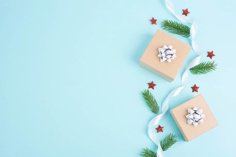 Christmas holiday greeting card with little gift boxes, stars and fir branches, blue background