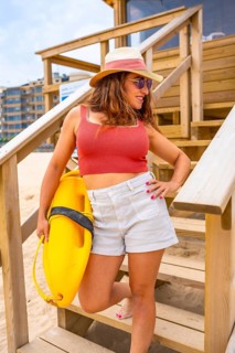 Portrait of caucasian woman at lifeguard tower enjoying summer on vacation on California coast