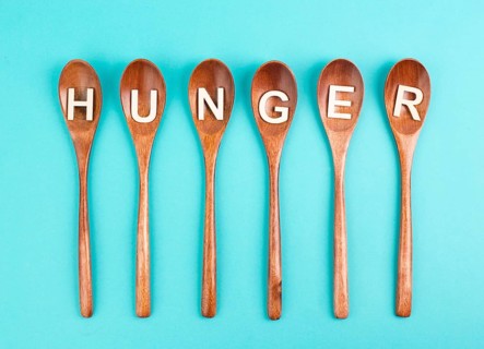 Hungry is standing in german language on the wooden spoons, food shortage and starving because of