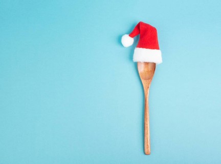 Blank paper with a wooden spoon and a red Santa Claus hat, christmas greeting card, copy space for