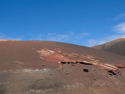 Red rocky landscape with barren ground and blue sky, arrecife, Lanzarote, Canary Islands, Spain,