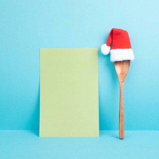 Blank paper with a wooden spoon and a red Santa Claus hat, christmas greeting card, copy space for