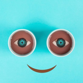 Cup of coffee building the eyes of the funny face, mouth is smiling, wake up in the morning, hot
