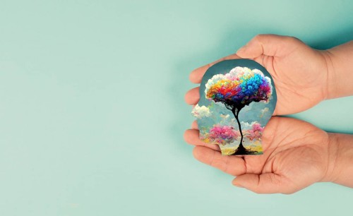 Holding a head with a colorful tree in the hands, symbol for creativity, connection to nature and