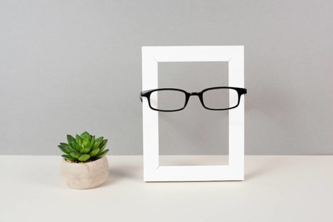 Home interior poster mock up with wooden frame, eyeglasses and cactus in a pot, gray wall