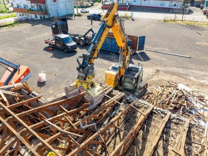 Aerial view of a construction site where an excavator is moving scrap and building material,