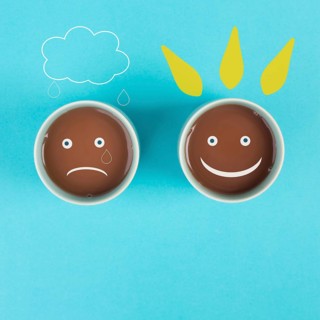 Cup of coffee with a sad and a happy face, positive and negative mindset, support and evaluation