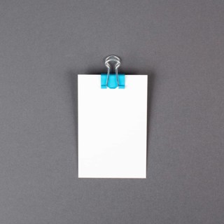 Blank white paper with a paperclip on a gray colored background, copy space for text, reminder or