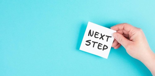 The phrase next step is standing on a paper, having new goals and strategies, making plans for