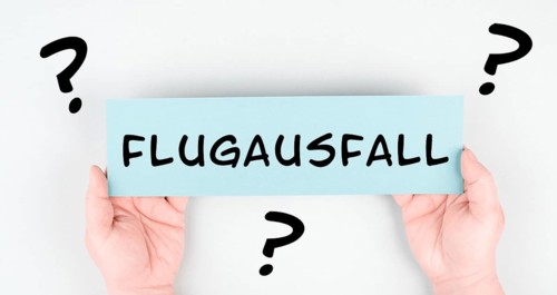 The word flight cancellation is standing in german language on the paper, staff shortage at the