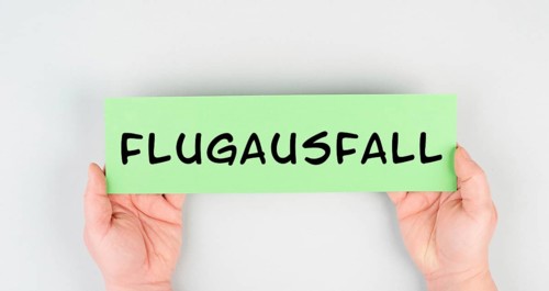 The word flight cancellation is standing in german language on the paper, staff shortage at the