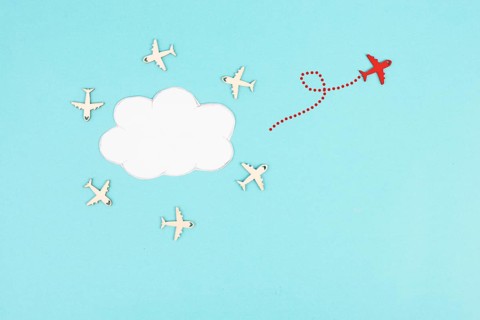Group of airplanes flying in a circle around a cloud, red plane thinks different and takes the