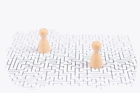 Men stand in the middle of a labyrinth, searching for a solution to exit, finding a strategy,