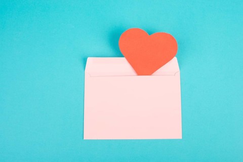 Pink envelope with a red heart, empty copy space, blue background, valintines day greeting card,