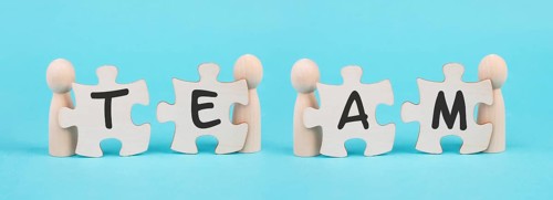 The word team is standing on puzzle pieces, connect the parts together, corporate in teamwork,