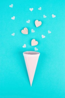 Cone with rose colored hearts, blue background, birthday and valentines day greeting card,