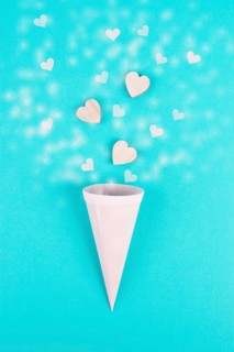 Cone with rose colored hearts, blue background, birthday and valentines day greeting card,