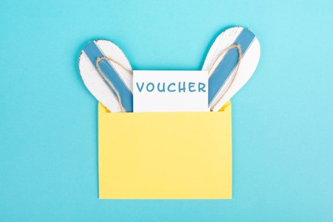 Blue colored summer and vacation background, voucher, flip flops in an envelope, copy space for