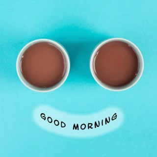 Cup of coffee building the eyes of the funny face, mouth with the phrase good morning, wake up in