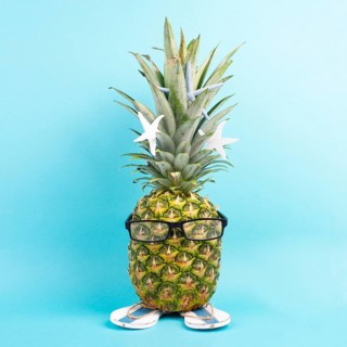Pineapple with glasses and flip flops, vacation and travel concept, tropical summer holiday, funny