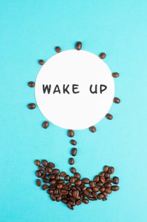 Flower made with coffee beans, the words wake up are standing on the blossom, good morning, having
