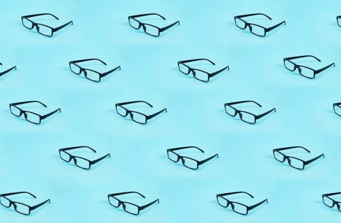 Many eyeglasses with a black frame on a blue background, copy space for text
