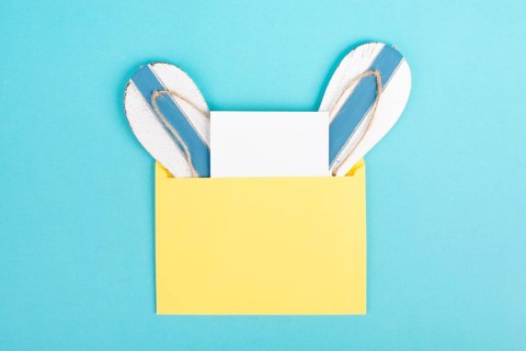 Blue colored summer and vacation background, flip flops in an envelope, copy space for text,