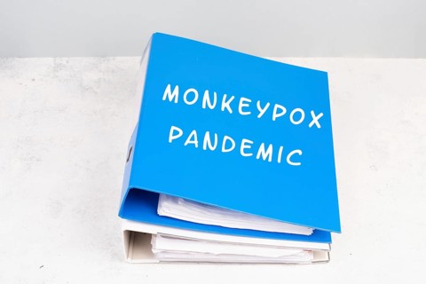 The words monkeypox pandemic are standing in german language on a folder, outbreak of the MPXV