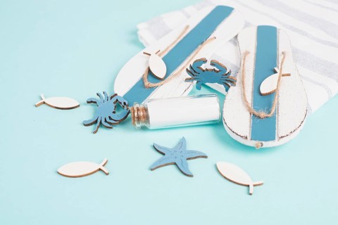 Blue colored summer and holiday background, flip flops, sea stars and a glass bootle with copy