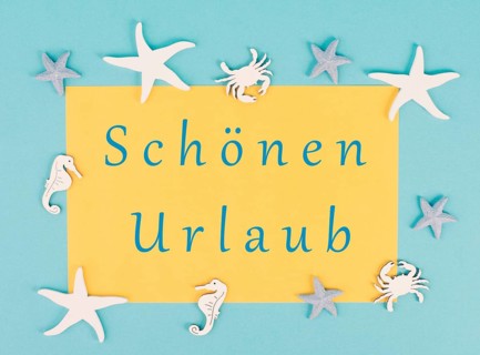 Yellow colored paper with the words nice vacation in german language, sea stars, seahorses and crab