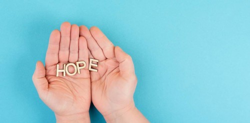 Holding the word hope in the palm of the hands, trust and believe concept, having faith in the