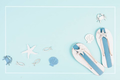 Blue colored summer and holiday background, flip flops, sea stars and fish with copy space, travel