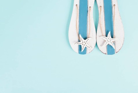 Blue colored summer and vacation background, slippers with sea stars, copy space for text, holiday