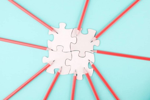 Working as a team, puzzle pieces connect together, pencils point to the jigsaw, brainstorming for