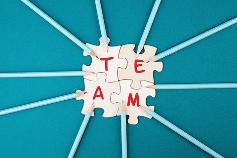 Working as a team, puzzle pieces connect together, pencils point to the jigsaw, brainstorming for