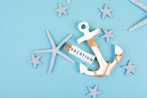 Blue colored summer and holiday background, anchor, sea stars and a glass bootle with the word