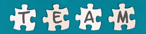 The word team is standing on puzzle pieces, connect the parts together, corporate in teamwork,