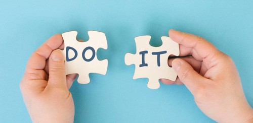 The words do it are standing on two puzzle pieces, positive mindset, motivation and coaching