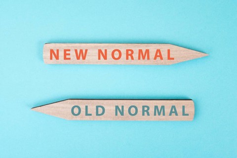 The words new and old normal are standing on wooden arrows, transformation of society after