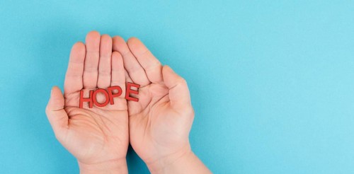 Holding the word hope in the palm of the hands, trust and believe concept, having faith in the