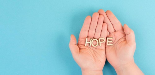 Holding the word hope in the palm of the hands, trust and believe concept, having faith in the
