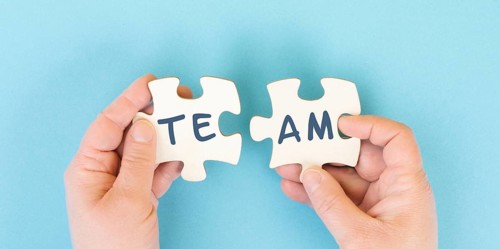 The word team is standing on puzzle pieces, connect the parts together, corporate in teamwork,
