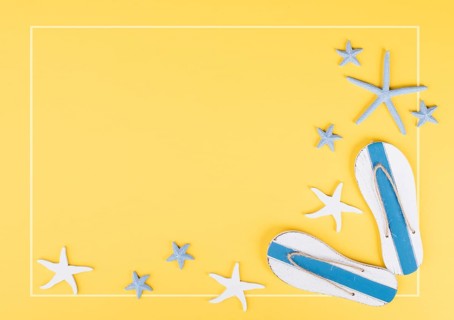 Yellow colored summer and vacation background, slippers and sea stars building a frame, copy space
