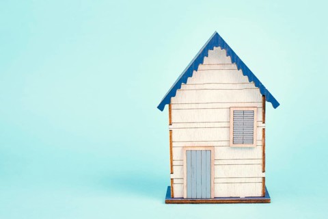 Wooden house, blue background, buying or renting a house, real estate concept, booking home for
