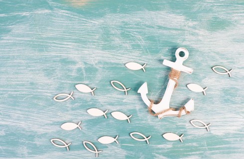 White anchor and fish on a blue background, maritime sea life, sailing trip, summer vacation,