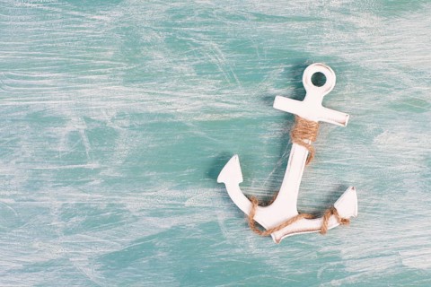White anchor on a blue textured background, maritime sea life, sailing trip, summer vacation,