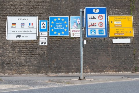 Border crossing to Germany, many road signs inform about speed limits and toll fees on german
