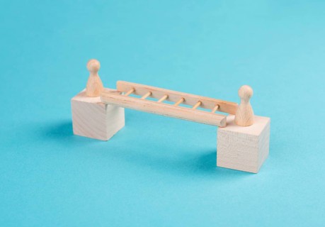 Two people connect by a ladder, buliding a bridge between men, separation and connection concept,