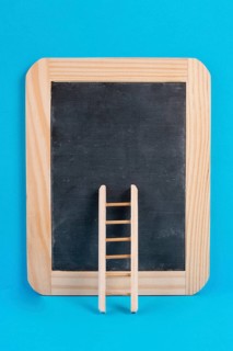 Ladder on an empty chalkboard, blue colored background, copy space, education, success, creative