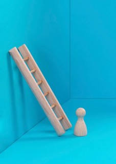 Man is standing next to a ladder, climbing up in career, having a goal, brainstorming for ideas,